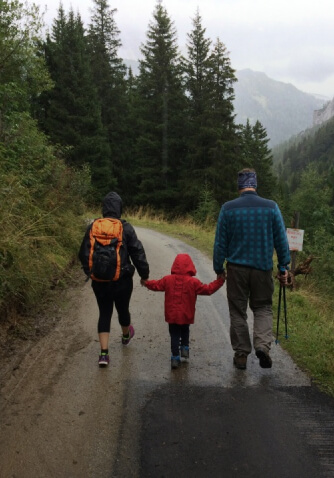 family walking on rainy trail