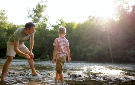 dad playing with son on creek