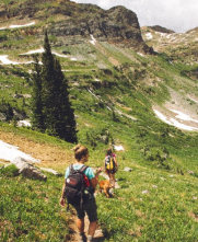 two people hiking on grassy mountain