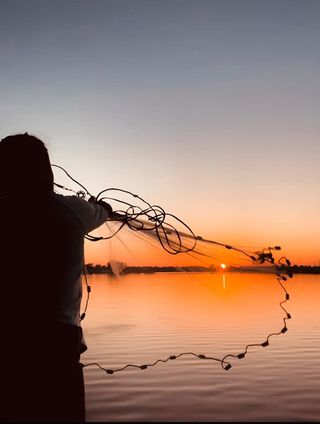 person casting fishing net